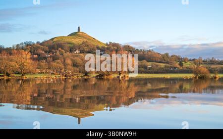 Ein Blick auf Glastonbury Tor im Winter am frühen Morgen von der Kuhbrücke über überflutete Felder von Lower Actis. Glastonbury, Somerset, England, Großbritannien Stockfoto