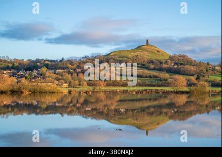Ein Blick auf Glastonbury Tor im Winter am frühen Morgen von der Kuhbrücke über überflutete Felder von Lower Actis. Glastonbury, Somerset, England, Großbritannien Stockfoto