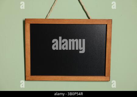 Eine leere kleine Tafel an hellgrüner Wand Stockfoto