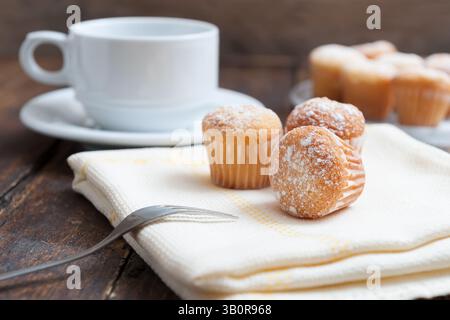 Muffins mit Kaffeetasse auf Holztisch Stockfoto