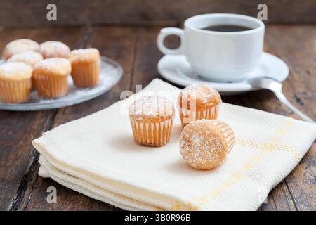 Muffins mit Kaffeetasse auf Holztisch Stockfoto