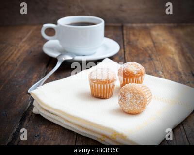 Muffins mit Kaffeetasse auf Holztisch Stockfoto