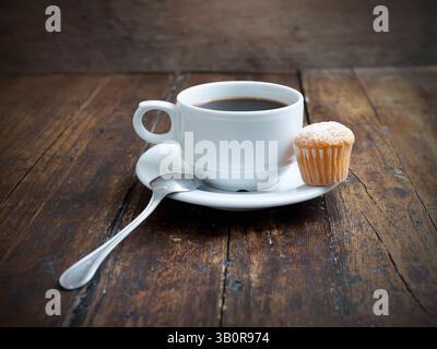 Muffins mit Kaffeetasse auf Holztisch Stockfoto