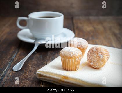 Muffins mit Kaffeetasse auf Holztisch Stockfoto