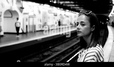 Junge Frau, die auf die U-Bahn in der Pariser U-Bahn-Station wartet Stockfoto