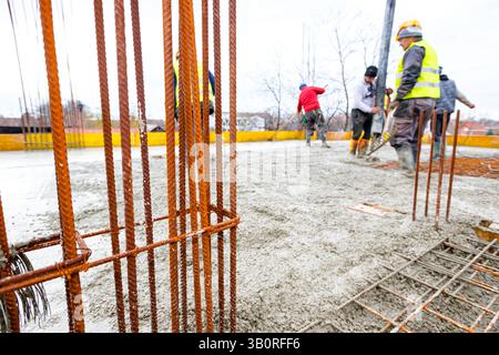 Nahaufnahme eingebauter rostiger Stahlstäbe, Betonverstärkung in der Gebäudestruktur, Baureife für den nächsten Bauabschnitt. Stockfoto