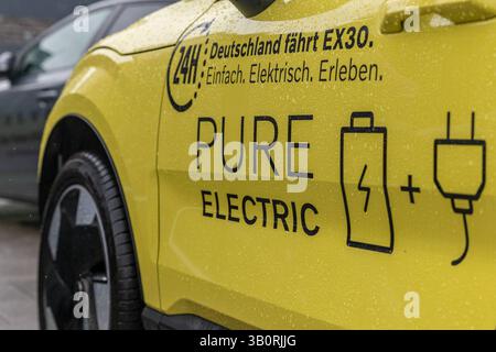 Volvo EX30 Elektromobilitätskampagne Deutschland fährt EX30 24.04.25, Selters: Symbolfoto, Illustrationsbild, Symbolbild, Illustrationsfoto, Alltagsszene Seitliche Nahaufnahme eines gelben Elektrofahrzeugs Volvo EX30 mit der Aufschrift Deutschland fährt EX30. Einfach. Elektrisch. Erleben. Sowie REIN ELEKTRISCH mit Symbolen für Batterie und Stecker. Das Fahrzeug ist mit Regentropfen bedeckt die Szene zeigt ein modernes Elektroauto im Rahmen einer bundesweiten Test- oder Marketingaktion. Symbolbild für Elektromobilität, Zukunft der Mobilität und nachhaltiger Verkehr. . . Selters Hessen Deutschland *** Stockfoto