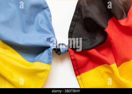 Die Fahnen Deutschlands und der Ukraine sind in einem Knoten gebunden und symbolisieren die union und die Freundschaft zwischen den Ländern, die Freundschaft der Völker Stockfoto