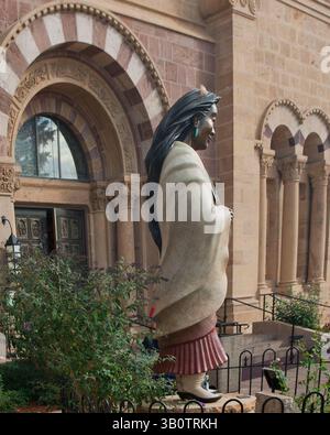 18. Oktober 2010 - Santa Fe, New Mexico, USA - Eine Statue von Kateri Tekakwitha (1656–1680), einem Konvertiten zum Christentum und dem ersten nordamerikanischen Inder, der als heilige befördert wurde (Bildhauerin Estella Loretto), steht vor dem Vordereingang der Kathedrale Basilica des Heiligen Franz von Assisi, der Mutterkirche der Erzdiözese Santa Fe, in der Hauptstadt von New Mexico. Erbaut von Erzbischof Jean Baptiste Lamy zwischen 1869 und 1886 an der Stelle einer älteren lehmkirche, aus gelbem Sandstein, der lokal abgebaut wurde, ist es ein beliebtes Touristenziel. (Bild: © Arnold Drapkin/ZUMAPRESS.com) Stockfoto