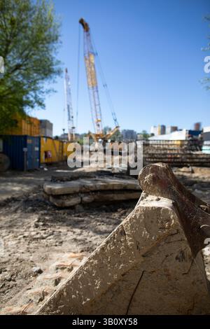 Eine geschäftige Baustelle, auf der Krane und schwere Maschinen, die an verschiedenen Aufgaben beteiligt sind, gezeigt werden Stockfoto