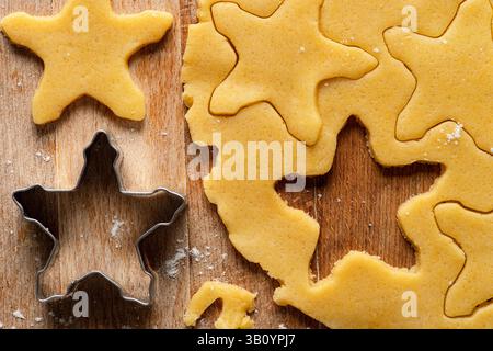 Die rohen Shortbread Biscuits und der ausgerollte Shortcrust-Teig werden auf ein hölzernes Schneidebrett gelegt. Draufsicht. Stockfoto