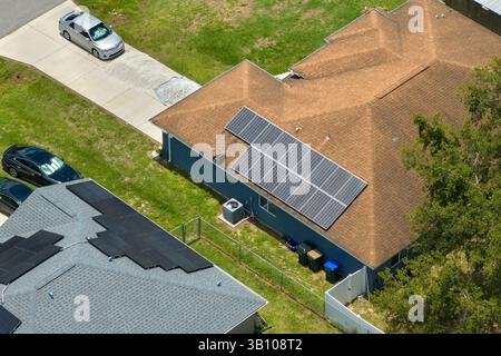 Luftaufnahme des amerikanischen Hausdachs mit blauen Solar-Photovoltaik-Panels zur Erzeugung sauberer ökologischer elektrischer Energie. Erneuerbarer Strom mit Null Stockfoto