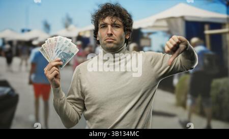 Hispanischer Mann, der polnische Zloty-Banknoten auf einer geschäftigen Stadtstraße zeigt, betont die Finanzierung im Freien. Stockfoto