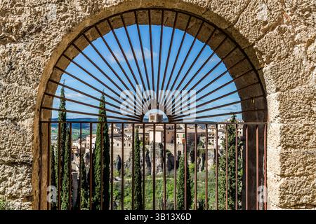 Blick auf die Stadt Cuenca durch das geschmiedete, bogenförmige Eingangstor zum Anwesen des Dichters Federico Muelas. Calle Larga, Cuenca, Castilla-La Mancha, Spanien Stockfoto