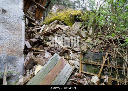Bad Illstern, italien, verlor seinen Platz. Bild eines eingestürzten Gebäudes, Trümmer und Vegetation verstreut. Linke Wand intakt, Anzeichen von Schäden. Gr Stockfoto