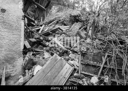 Bad Illstern, italien, verlor seinen Platz. Schwarzweißbild eines eingestürzten Gebäudes mit Schutt und Schutt. Bewachsene Vegetation und Bäume sind in sichtbar Stockfoto