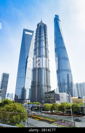 Shanghai, China - 1. April 2025: Lujiazuis ikonische Skyline: Shanghai Tower, Jin Mao Tower und Shanghai World Financial Center, umrahmt von Grün und Stockfoto