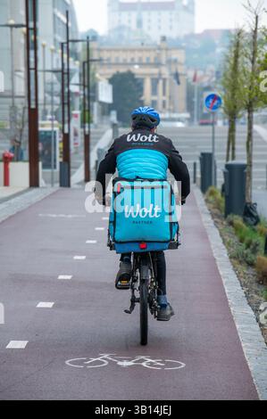 Bratislava, Slowakei - 15. April 2025 : Wolt Fahrradkurier bei der Arbeit in Bratislava. Essenslieferservice. Stockfoto