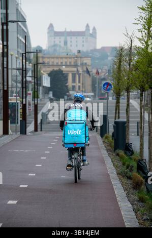 Bratislava, Slowakei - 15. April 2025 : Wolt Fahrradkurier bei der Arbeit in Bratislava. Essenslieferservice. Stockfoto