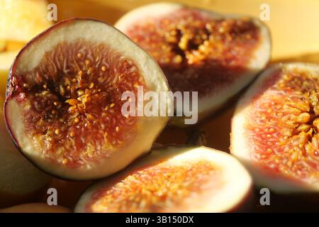 Geschnittene frische Feigen auf einem Holzteller bei Tageslicht Stockfoto