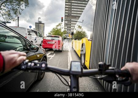 Radfahren in der Stadt, Stadtstraße, kein Radweg, Bushaltestelle, zweispuriger Verkehr in beide Richtungen, Radfahrerperspektive, Essen, Nordrhein-Westpha Stockfoto