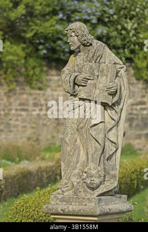 Apostel Matthäus mit Kopf als Symbol, heiliger, Evangelist, evangelistisches Symbol, Steinskulptur, Klostergarten, St. Mauritius, Benediktinerabtei, Stockfoto