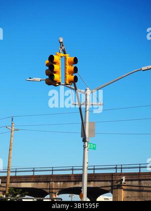 Helle gelbe Ampeln vor einem klaren blauen Himmel in Far Rockaway, New York Stockfoto