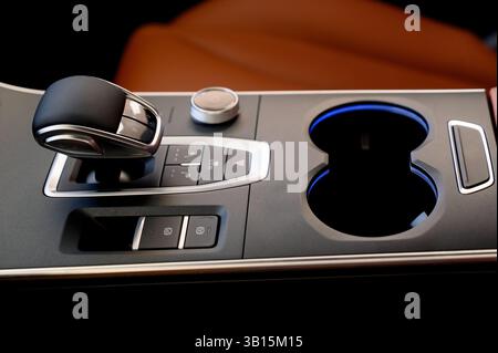Wählautomatik mit Leder im Innenraum eines modernen, teuren Autos. Schwarzes und braunes Lederauto. Modernes Automatikgetriebe. Schließen Sie u Stockfoto