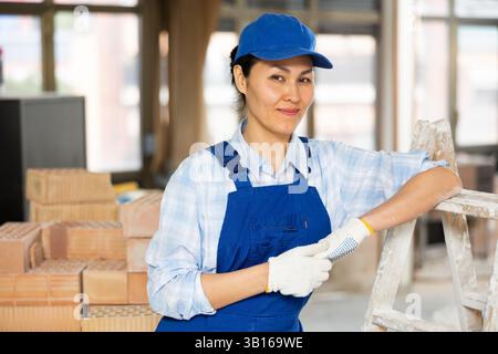 Porträt einer Bauherrin, die in der Nähe einer Stehleiter steht Stockfoto