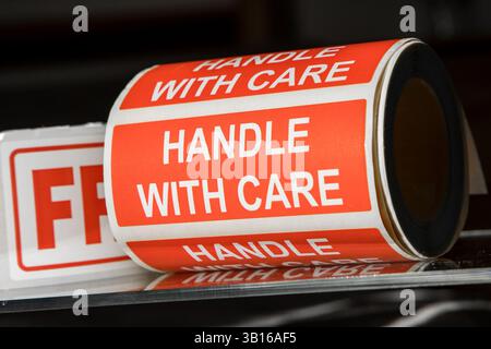 Zerbrechlicher Griff mit Rolle für Pflegeaufkleber. Warnschilder Aufkleber Klebeband. Stockfoto
