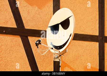 Satellitenschüssel mit Smiley an einer Hauswand in Langenstein, Deutschland, Sachsen-Anhalt, Halberstadt Stockfoto