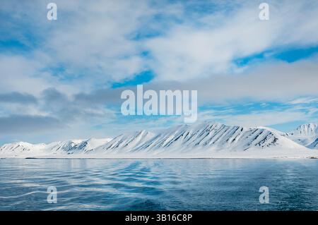 Schneebedeckte Berge an der Küste in der Nähe des Monaco-Gletschers, Norwegen, Svalbard Stockfoto