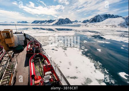 Blick von einem Kreuzfahrtschiff auf schneebedeckte Berge an der Küste und den Monaco-Gletscher, Norwegen, Svalbard Stockfoto