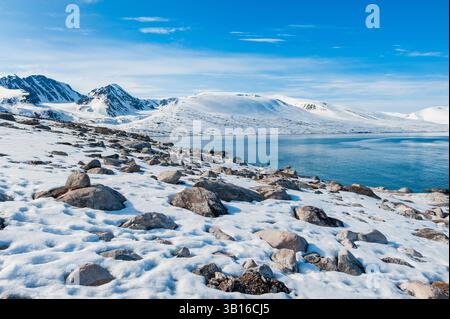 Schneebedeckte Felsenstrände und Berge am Bockfjorden, Norwegen, Svalbard Stockfoto
