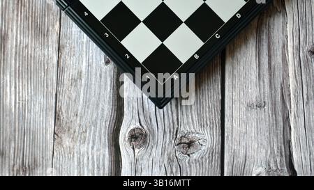 Schachbrett auf dem Holztisch. Schwarzes Schachbrettspiel. Schwarz-weiße Schachfiguren. Schach spielen Stockfoto