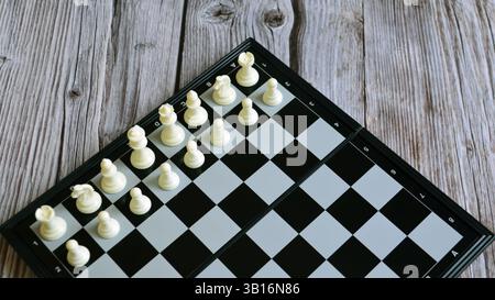 Schachbrett mit Schachfiguren auf dem Holztisch. Schwarzes Schachbrett. Schachfiguren auf dem Brett. Schachspiel Stockfoto