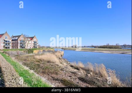 Wohnungen mit Stufengiebeln am Ufer des Boven Merwede in Gorinchem, mit Blick auf die Flusslandschaft; Zuid-Holland, Niederlande Stockfoto
