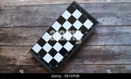 Schachbrett auf dem Holztisch. Schwarzes Schachbrettspiel. Schwarz-weiße Schachfiguren. Schach spielen Stockfoto