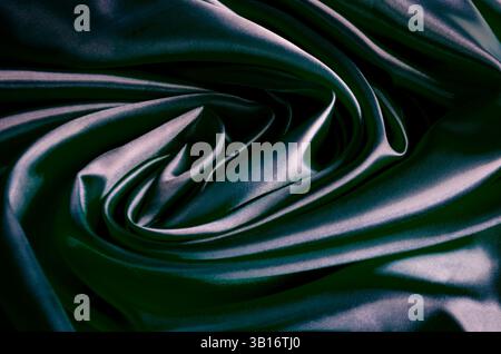Blick von oben auf poliertes dunkelgraues Seidentuch mit seidenweichem Glanz und wunderschönen natürlichen Vorhängen. Geeignet für Design und Hintergrundtapeten. Stockfoto