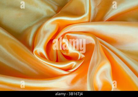 Goldene gelbe Seide mit seidenem Glanz, geeignet für Design und Tapetenhintergrund. Stockfoto