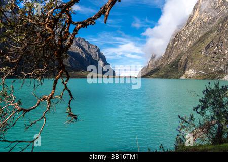 Ein atemberaubender türkisfarbener See reflektiert den blauen Himmel, eingebettet zwischen hoch aufragenden Bergen. Die friedliche Landschaft ist Teil der berühmten Laguna 69 Trek in Hu Stockfoto