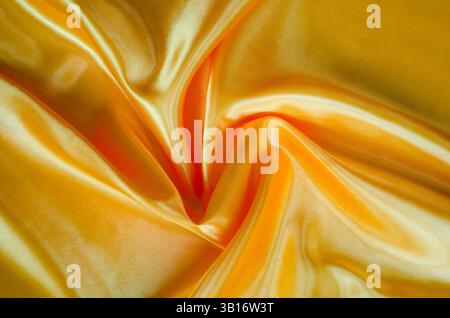 Draufsicht auf goldgelb glänzenden seidenen Glanz, geeignet für Design und Tapetendekoration. Stockfoto