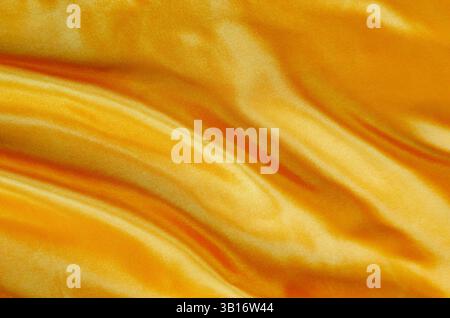 Gelbes Seidentuch mit seidenem Glanz, geeignet für Design und Tapetenhintergrund. Stockfoto