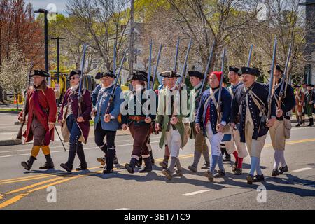 Arlington, MA, USA-20. April 2025: Battle of Menotomy 250th Reenactment – patriotische Kolonialisten kämpfen gegen britische Soldaten auf der Massachusetts Avenue. Stockfoto