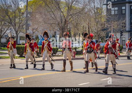 Arlington, MA, USA-20. April 2025: Battle of Menotomy 250th Reenactment – patriotische Kolonialisten kämpfen gegen britische Soldaten auf der Massachusetts Avenue. Stockfoto