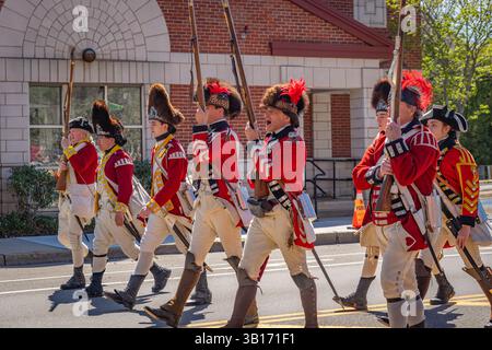 Arlington, MA, USA-20. April 2025: Battle of Menotomy 250th Reenactment – patriotische Kolonialisten kämpfen gegen britische Soldaten auf der Massachusetts Avenue. Stockfoto