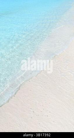 Top view of tropical beach with white sand and clear blue ocean turquoise water in natural sunlight, minimalist peaceful scenery background Stockfoto