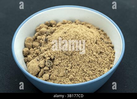 Organic Brown Sugar Bowl: Eine Nahaufnahme einer hellfarbigen braunen Zuckerschale, gefüllt mit biologischem grobem braunem Zucker, die die Textur und den Reichtum von zeigt Stockfoto