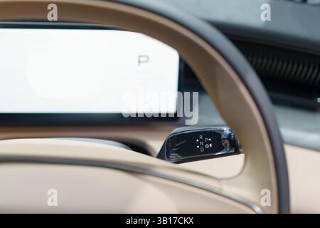 Detaillierte Ansicht des Lenkrads und des Gangschalters eines modernen Elektrofahrzeugs mit elegantem Innendesign und fortschrittlicher Technologie. Stockfoto