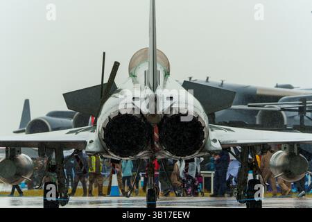 Rückansicht eines RAF Eurofighter Typhoon-Kampfflugzeugs, das bei regnerischem Wetter auf einer Flugschau ausgestellt wird, mit Menschenmassen im Hintergrund. Stockfoto